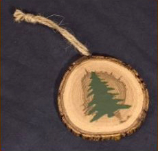 A Christmas tree ornament on an actual pine log sliver. christmas-tree-on-pine-log-ornament.jpg