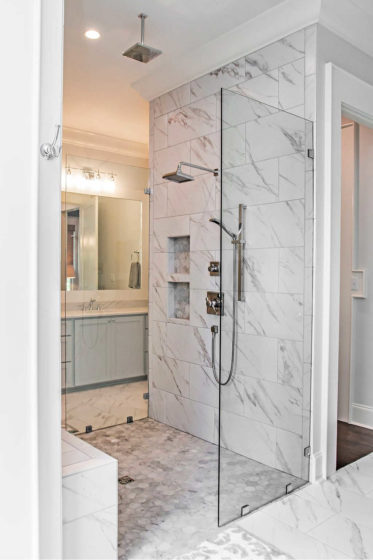 This his & her walk-in shower has a tall piece of clear glass on either side, but no door!