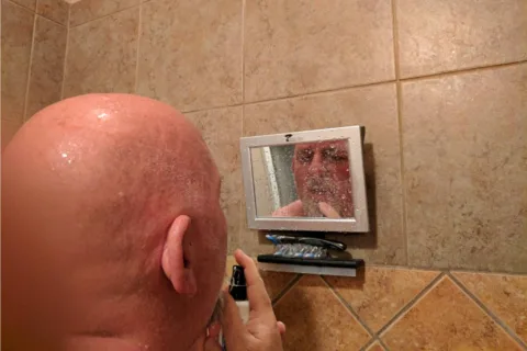 My husband Jim using his ToiletTree fogless mirror for shaving.