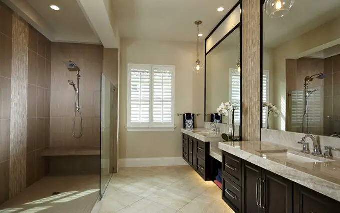 A doorless shower with a short glass wall in the master bathroom.