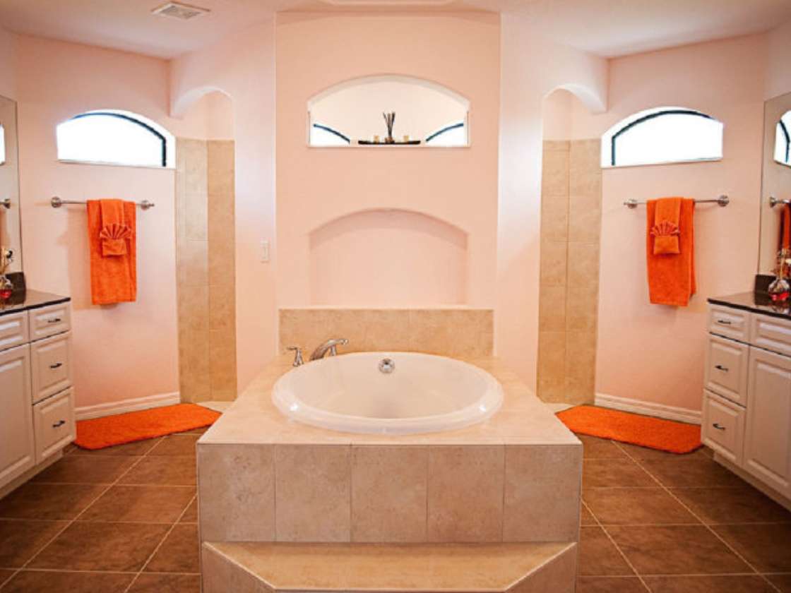 A master bathroom with a floating wall separating the walk-in shower from the bathtub. 
