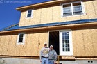 Matt and April in front of their log home, which is currently under construction.